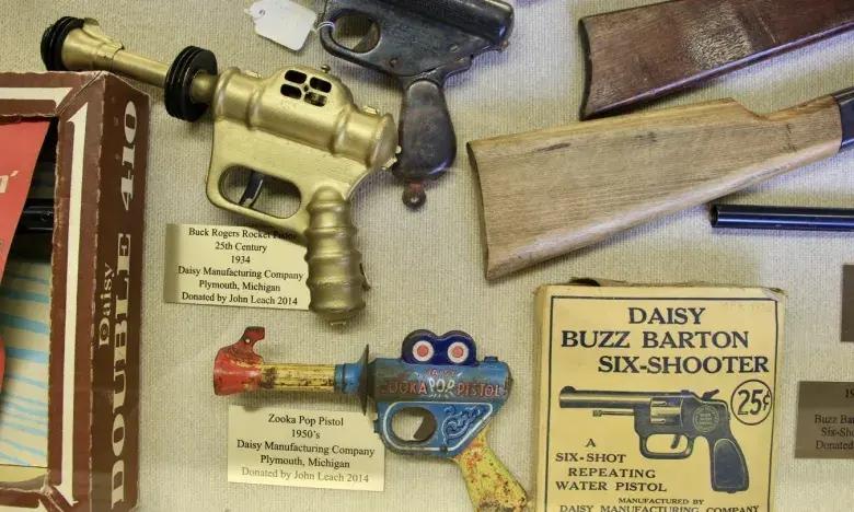 Vintage toy ray guns and rifles displayed with packaging.