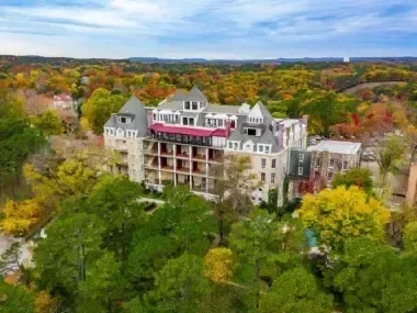 Victorian-style building among colorful autumn trees.