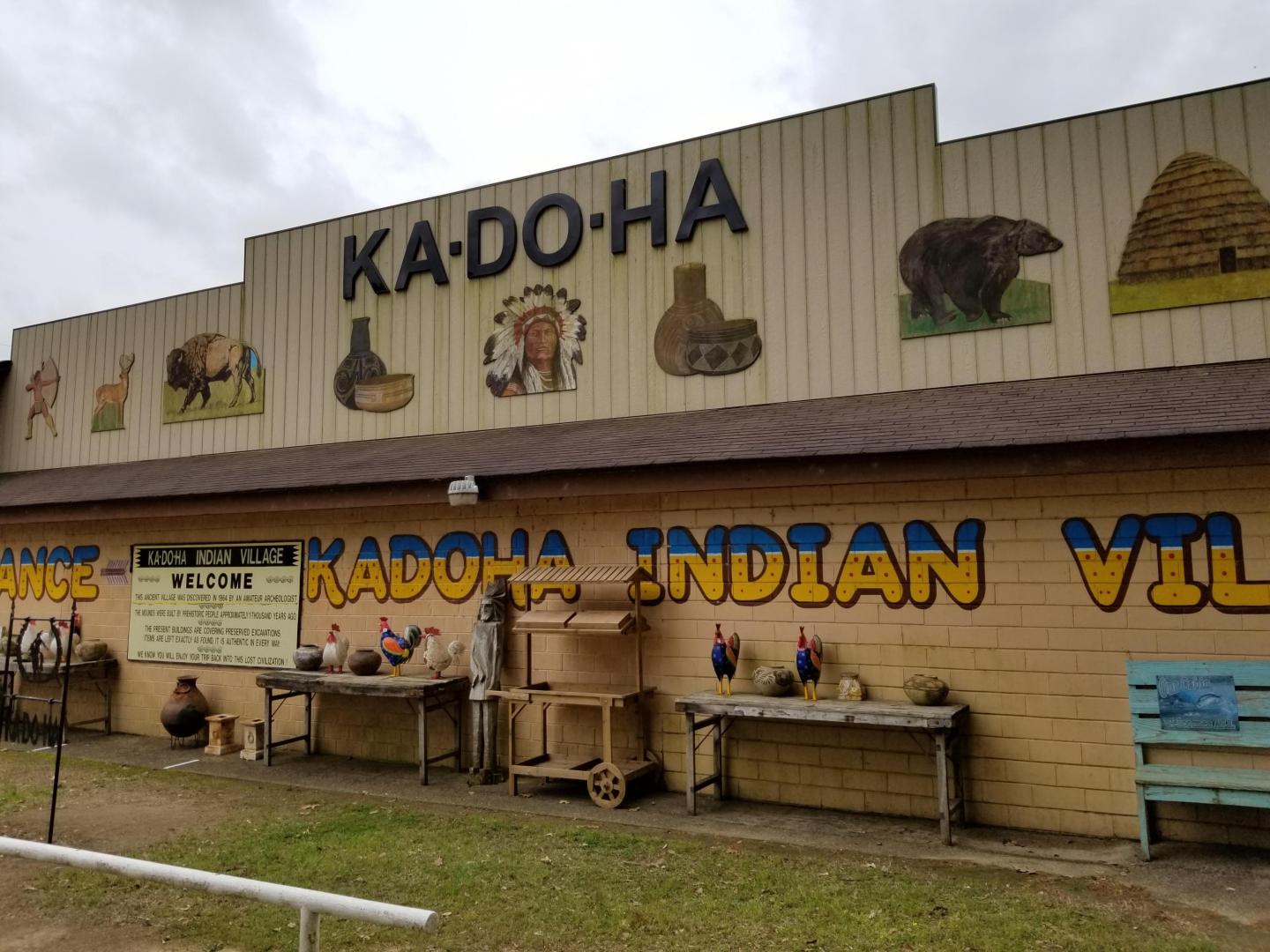 Kadoha Indian Village building with murals and native artifacts displayed outside.
