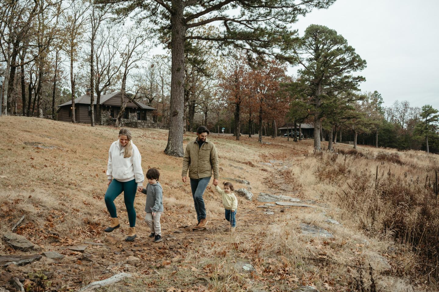 Family walking in a wooded area with fall foliage.