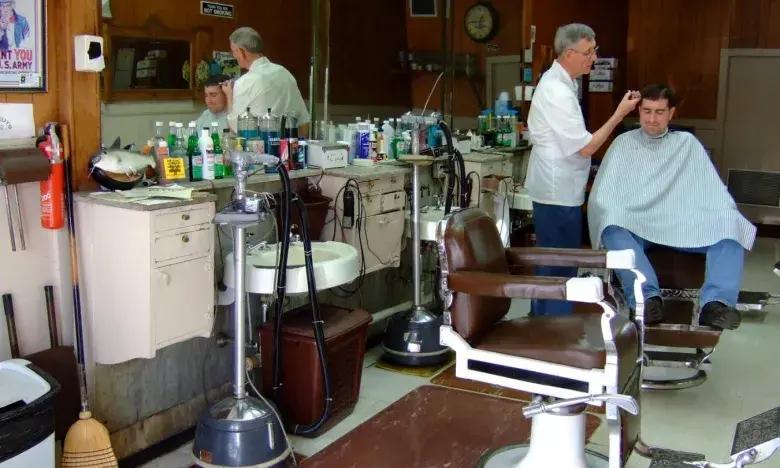 Barber cutting a customer's hair in a vintage barber shop.