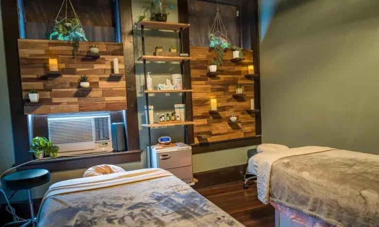 Cozy massage room with two beds and warm lighting.