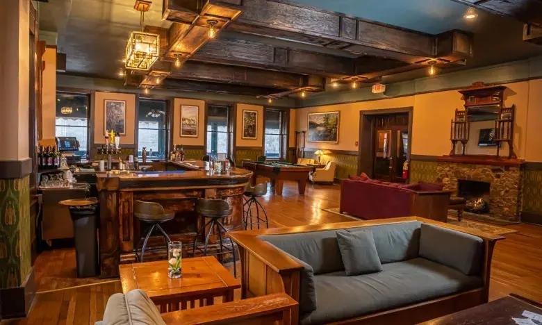 Cozy lounge with wooden beams, sofas, and warm lighting.