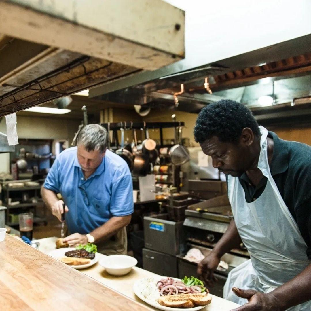 Chefs preparing dishes in a busy kitchen, focused and attentive.