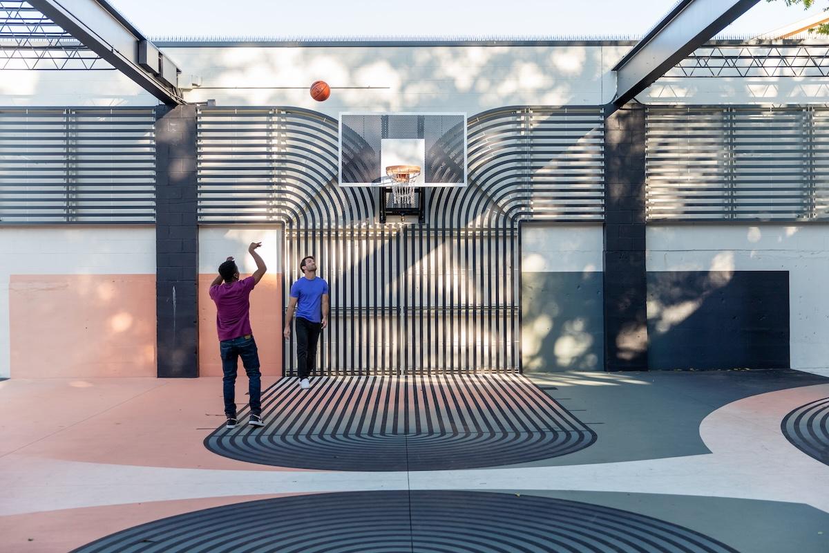 Two people playing basketball on a colorful court.