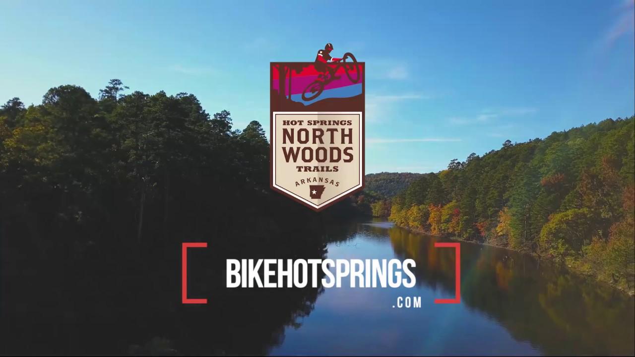 Logo of Northwoods Trails above a serene forest and river landscape.