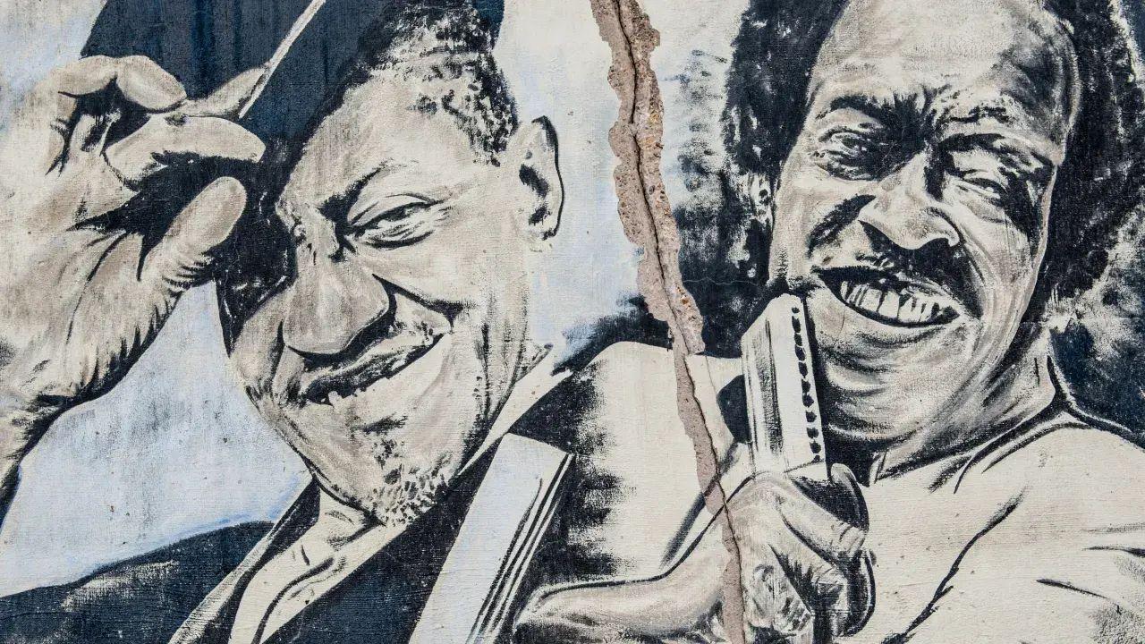 Mural of two smiling musicians, one tipping his hat, the other holding a harmonica.