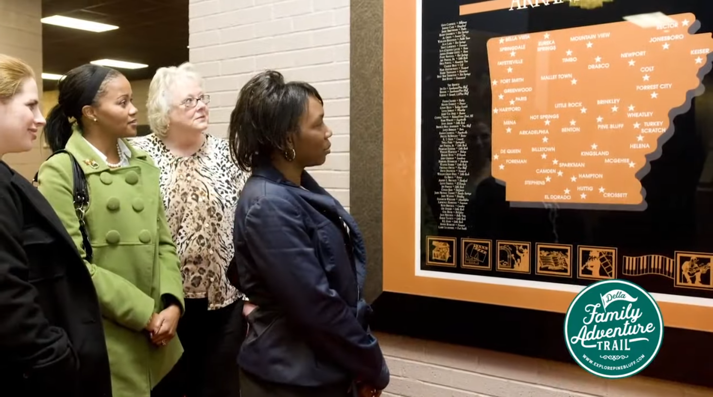People observing a framed map display in a museum setting.