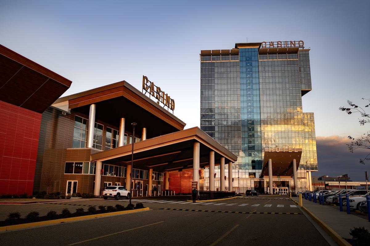Casino entrance with modern glass building at sunset.