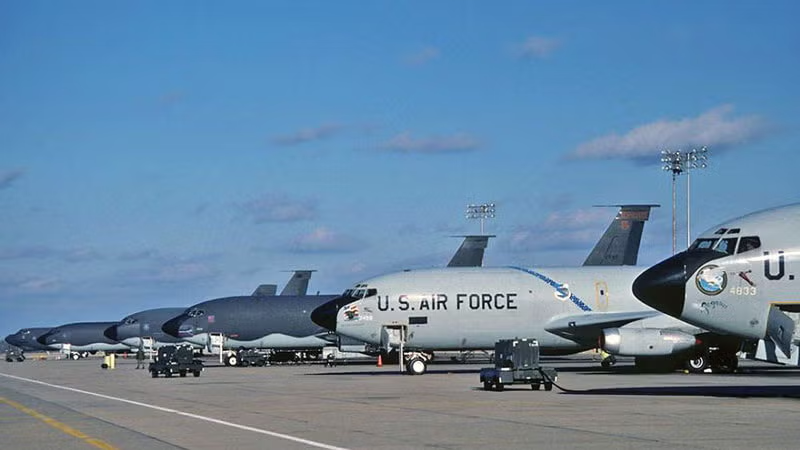 U.S. Air Force planes lined up on a runway under a blue sky.