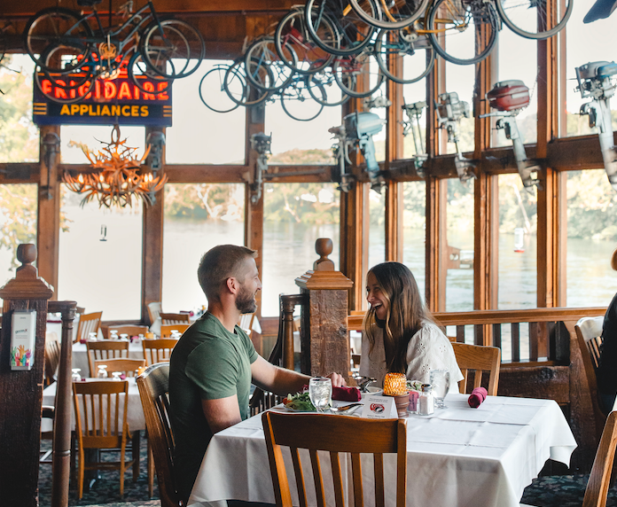 Cozy restaurant with a couple dining at a table, bicycles hung from ceiling.