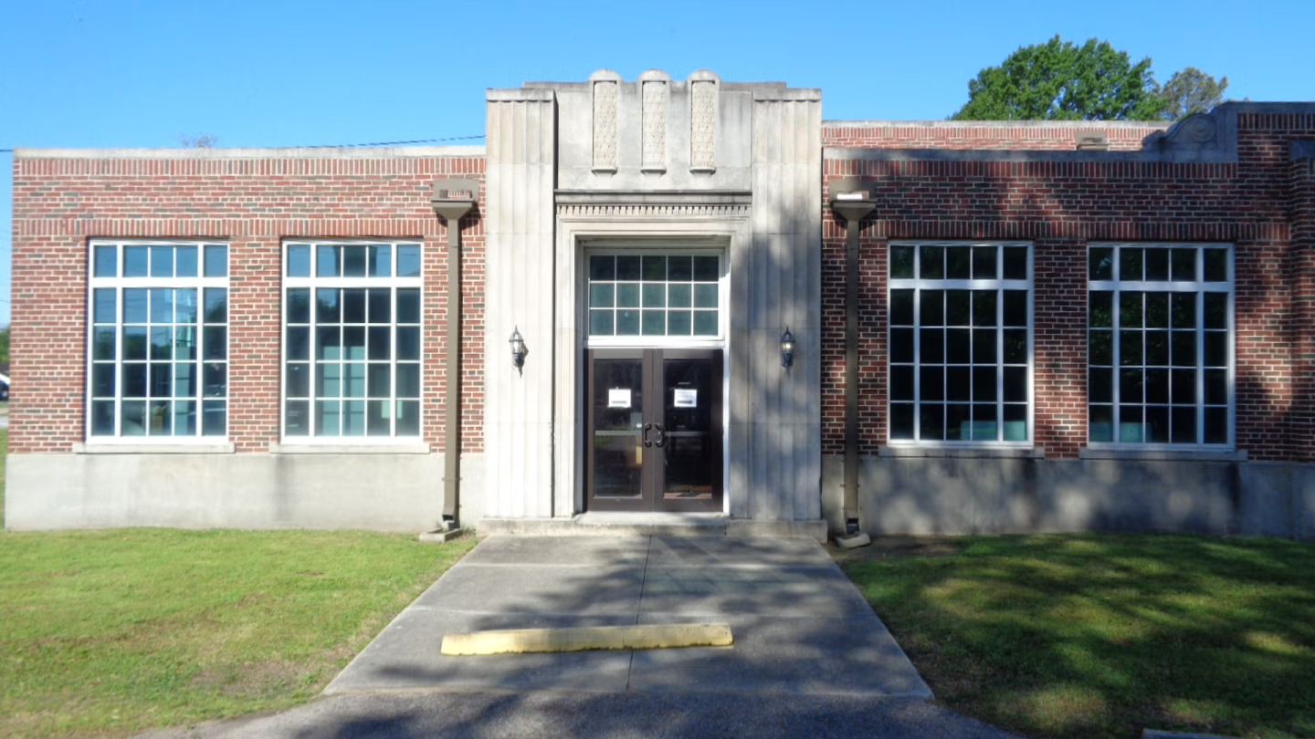 Brick building with large windows and central entrance.