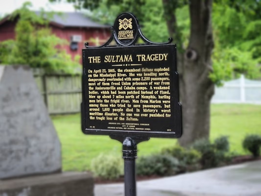 Historic plaque titled "The Sultana Tragedy" in a park setting.