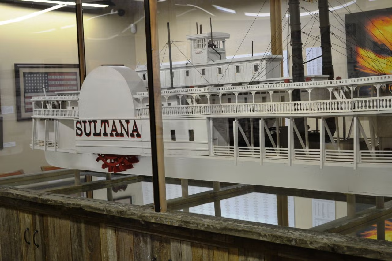 Model steamboat named "Sultana" displayed behind glass.