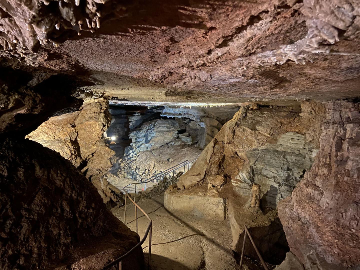 Cave interior with stalactites, rock walls, and dim lighting.