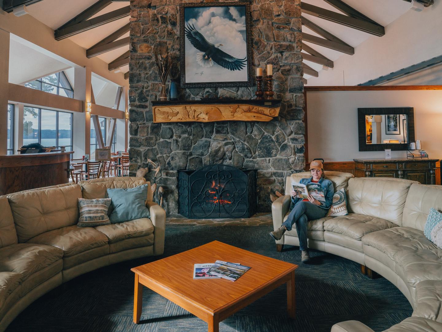 Cozy lodge room with stone fireplace and beige sofas.