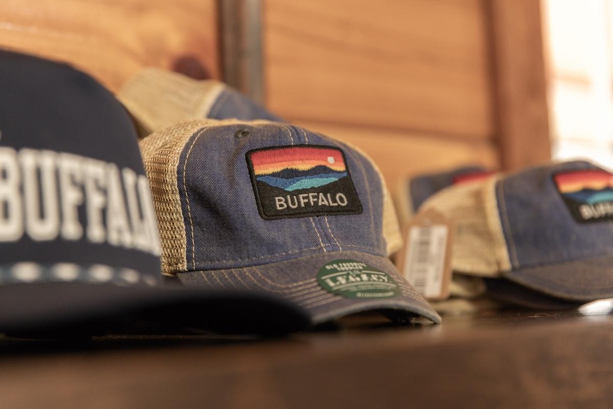 Caps on display, featuring "Buffalo" and mountain design patches.