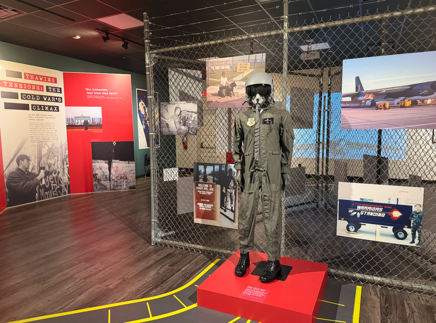 Museum display with a pilot mannequin, photos, and informational panels.