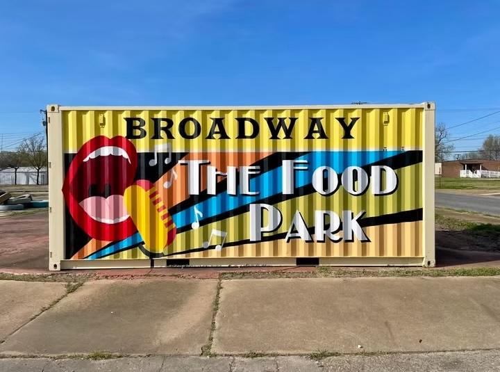 Broadway Food Park mural on a shipping container, vibrant colors, clear sky.