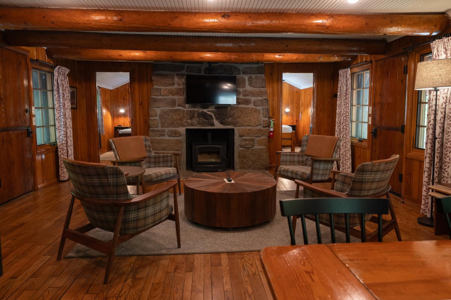 Cozy wooden cabin interior with fireplace and armchairs.