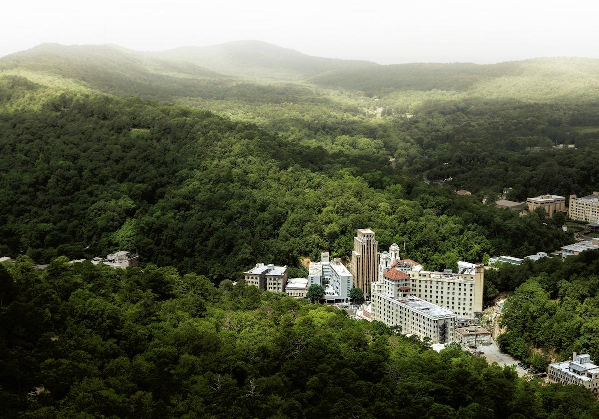 Cityscape surrounded by lush green hills.