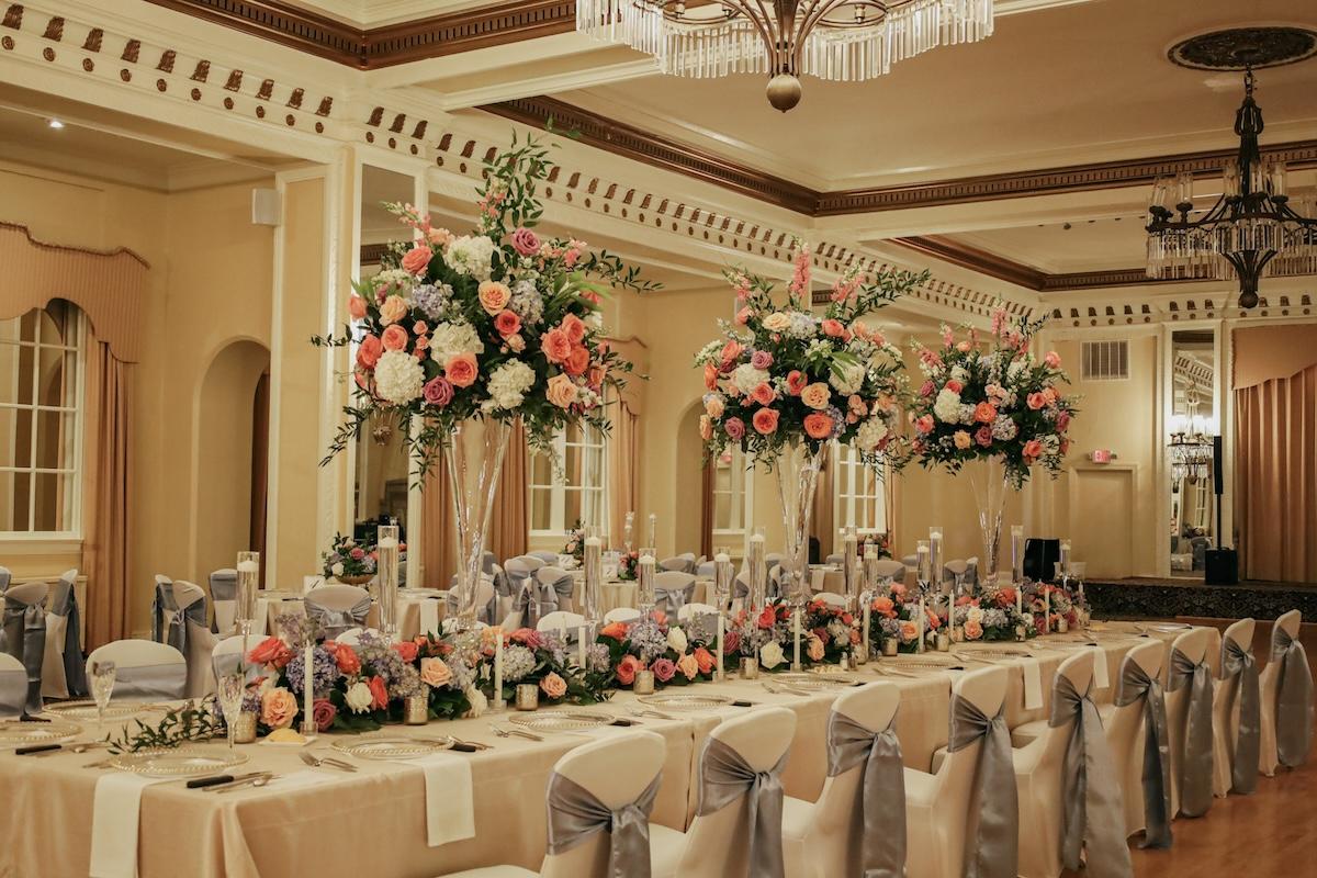 Elegant banquet hall with floral centerpieces and adorned tables.