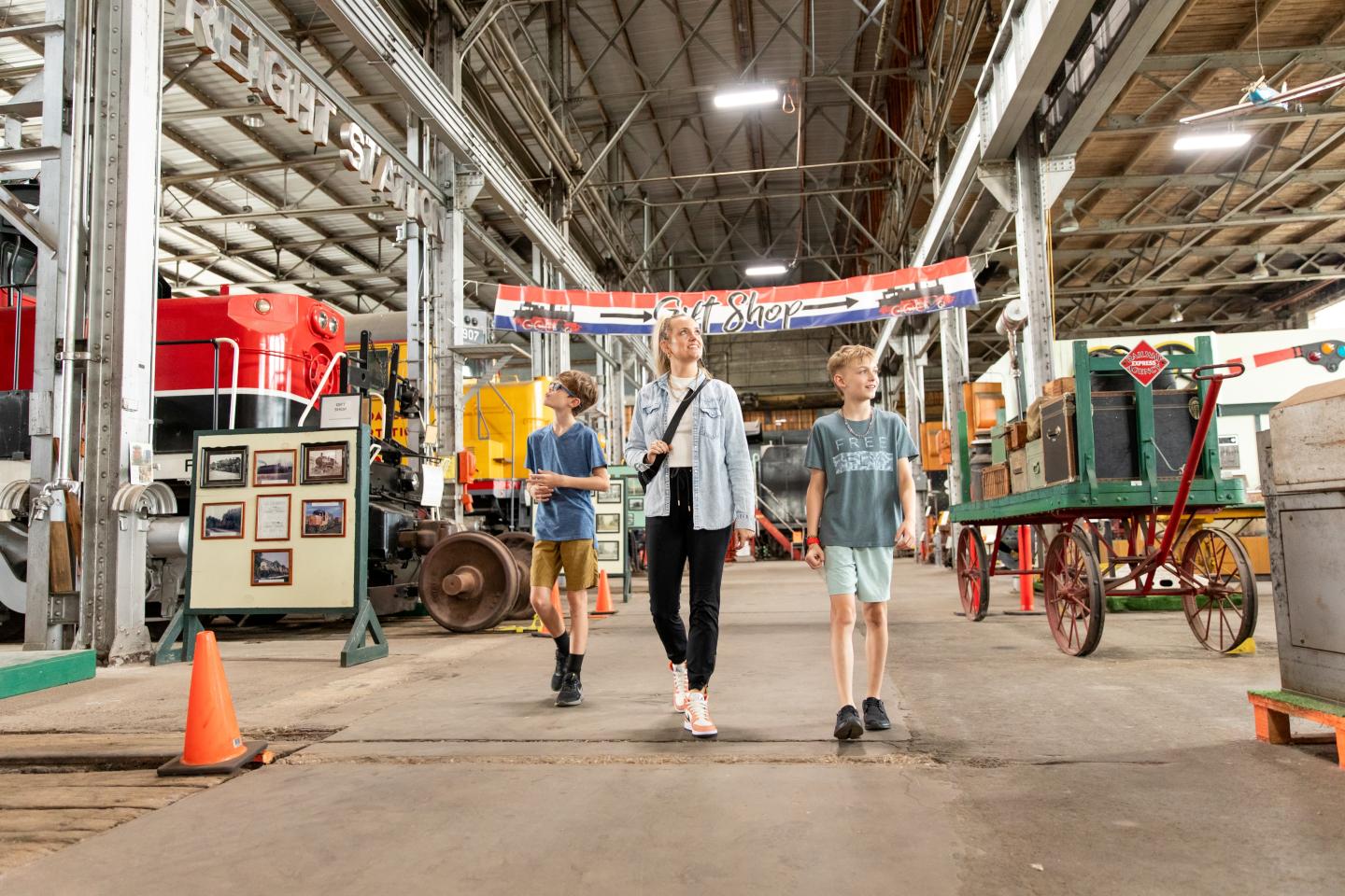 Family walking through a train museum hall.