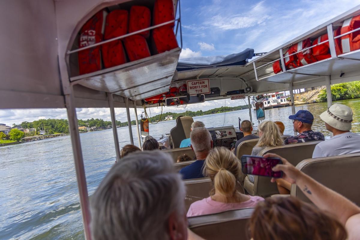Boat passengers enjoying a sunny lake ride.