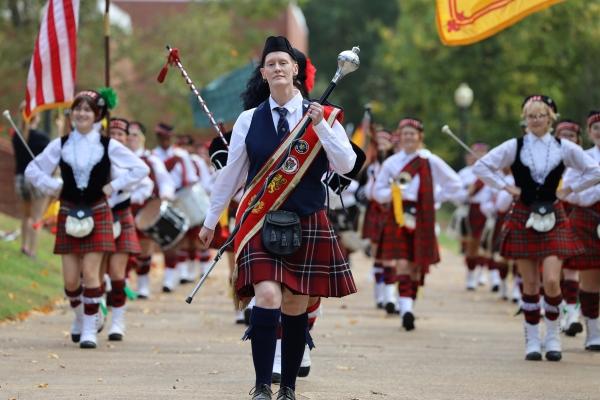 Scottish marching band in kilts on a fall street.
