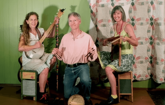 Three musicians playing instruments indoors.