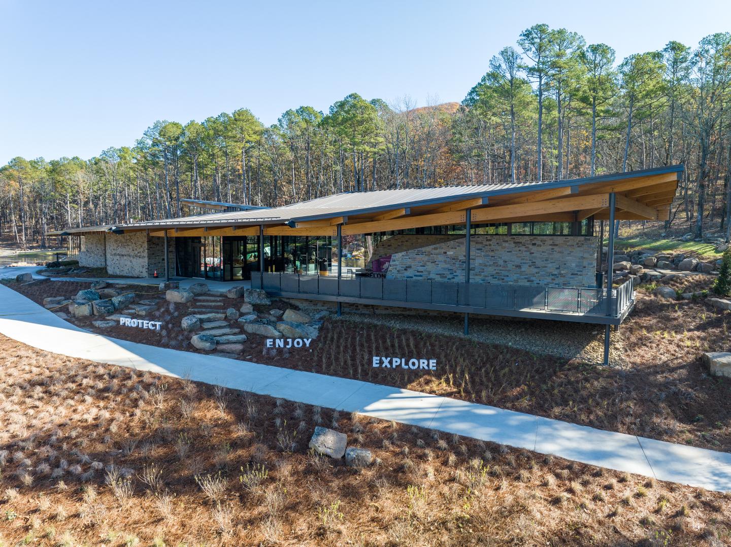 Modern building with a sloped roof surrounded by trees.