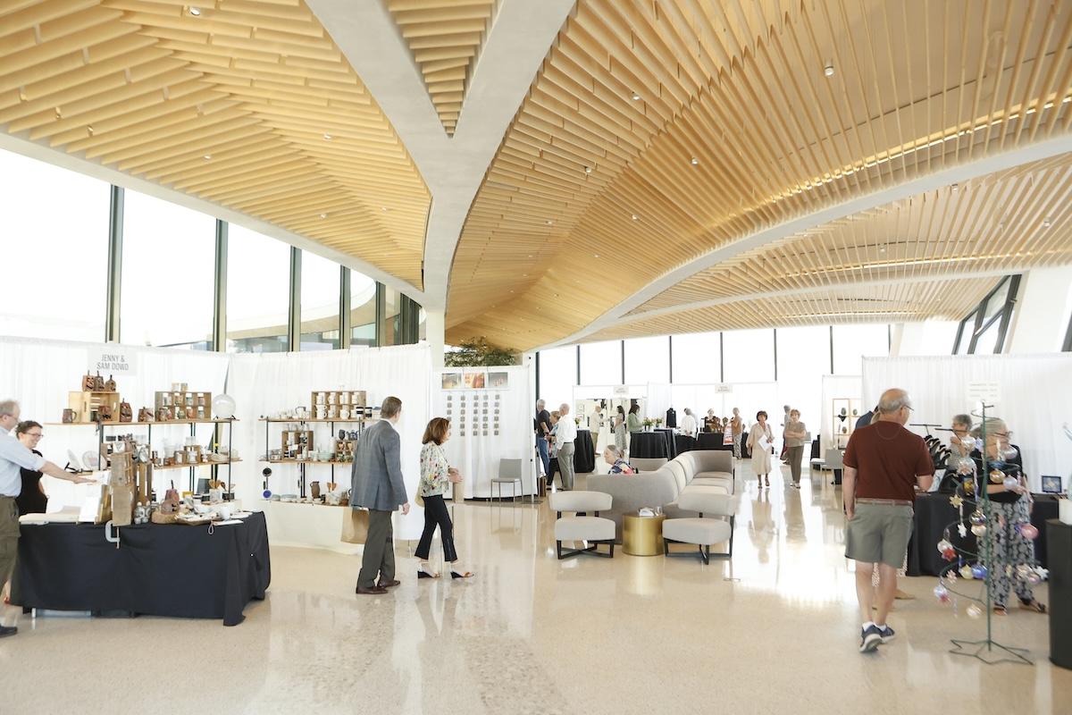 Modern art gallery with visitors browsing various exhibits.