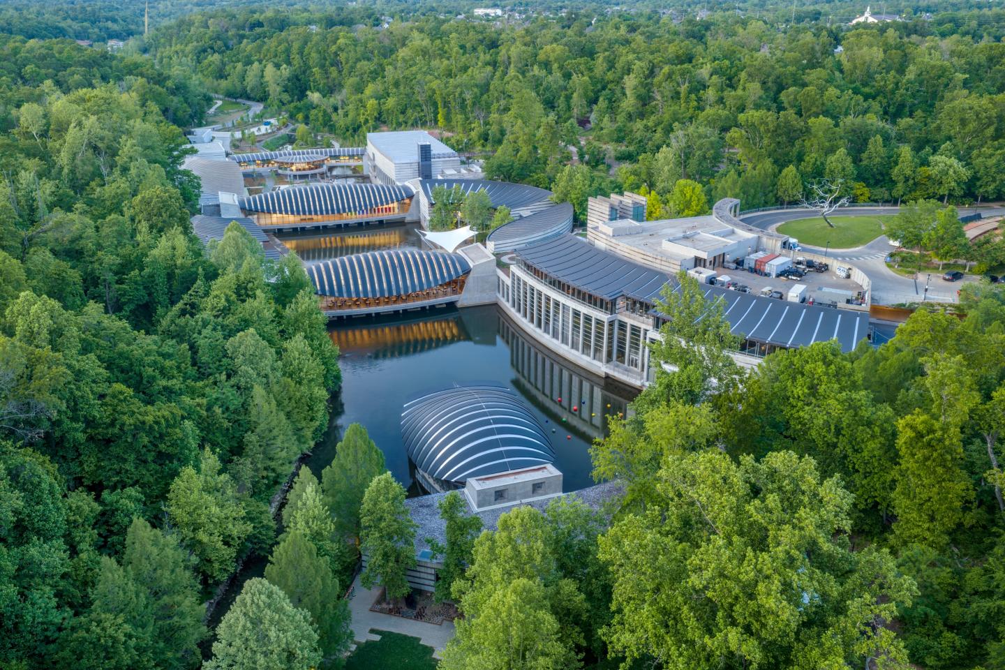 Aerial view of modern buildings surrounded by lush green forest.