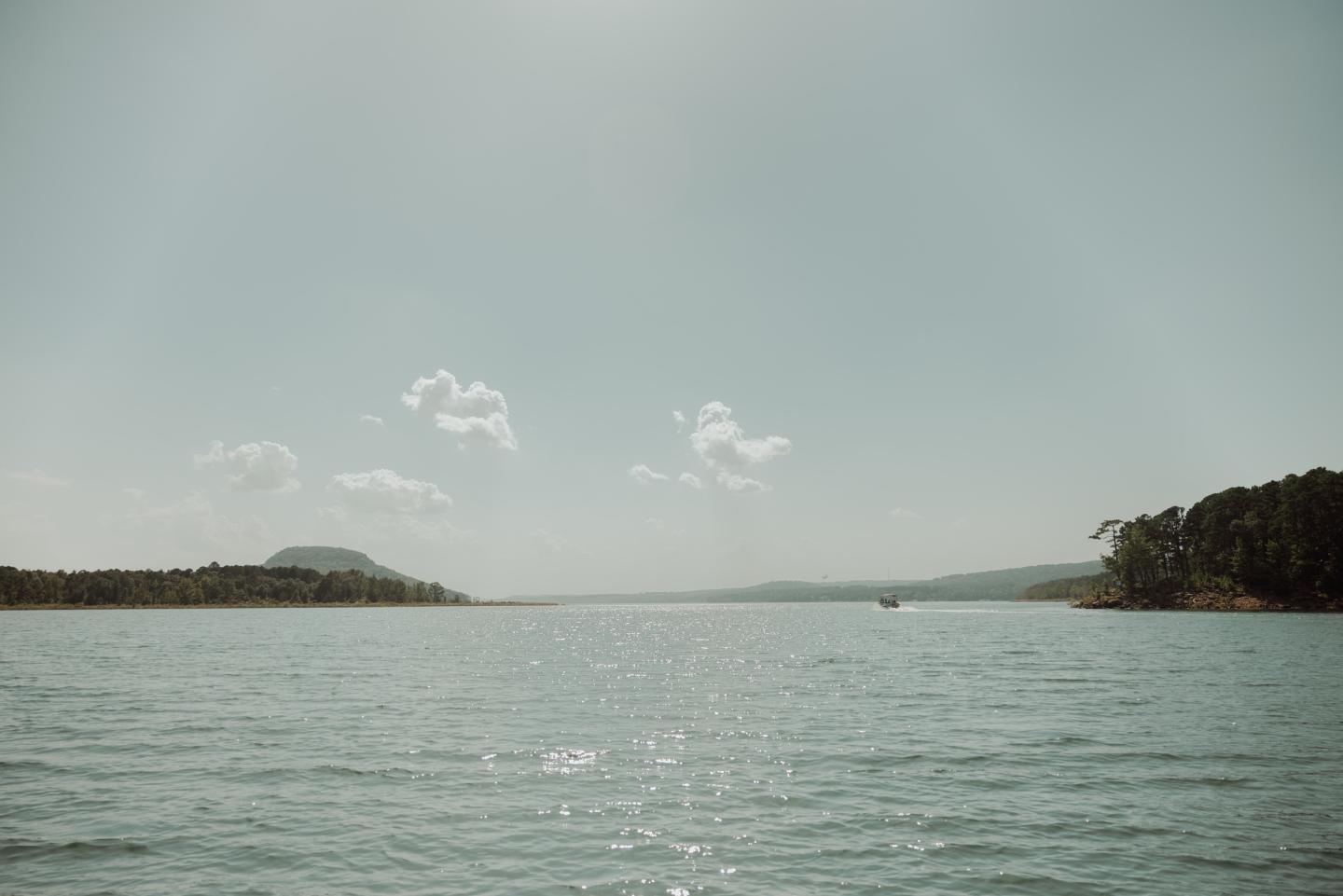 Calm lake with distant hills under a clear sky.