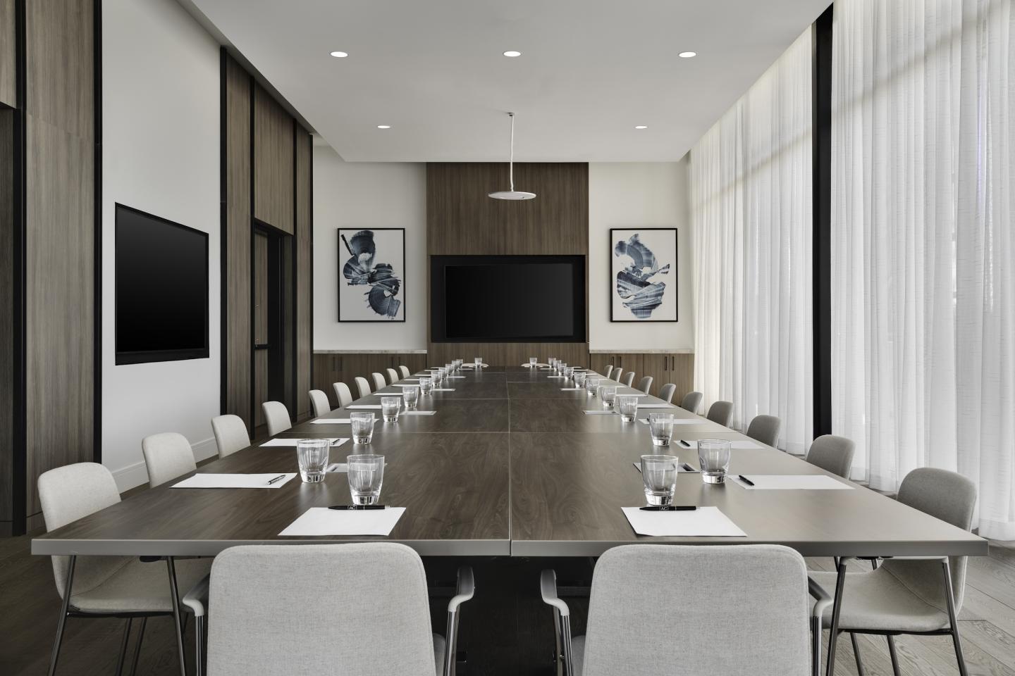 Spacious conference room with a long table and modern decor.