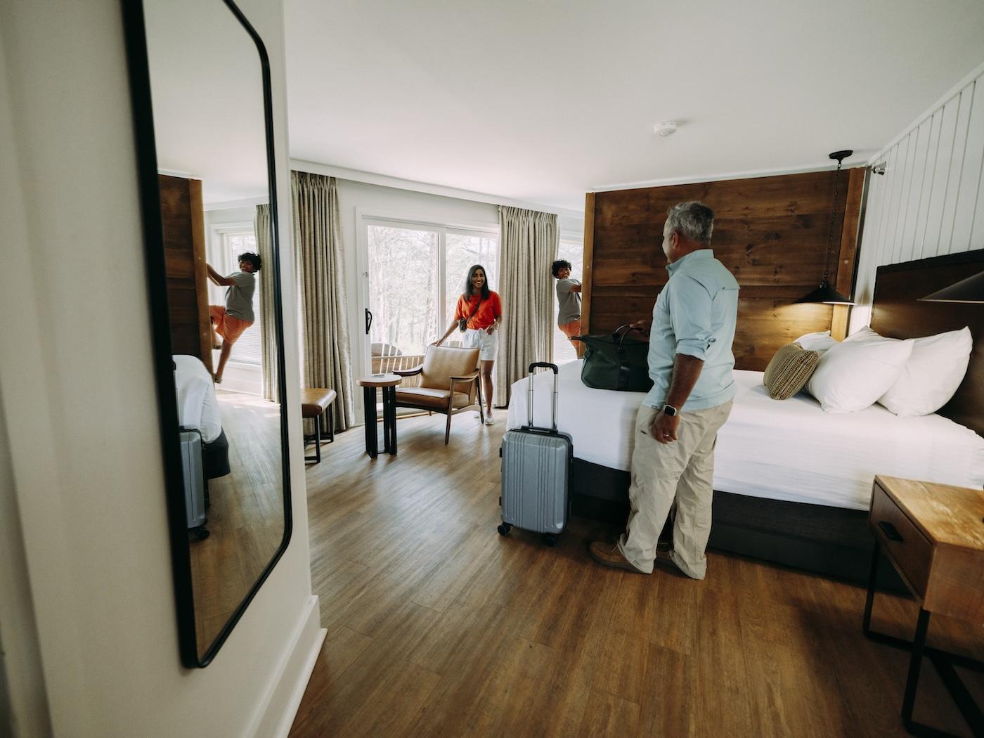 Couple packing luggage in a bright modern bedroom with wooden floors