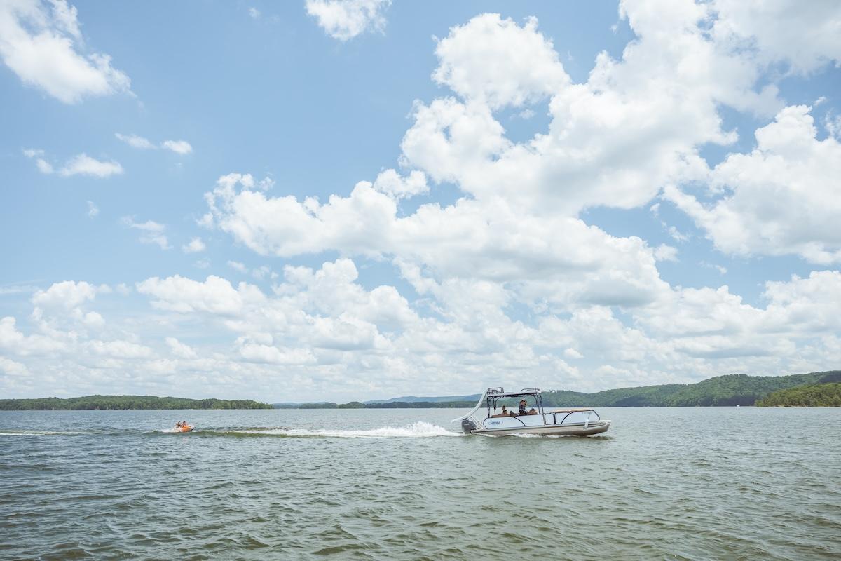 Speedboat on a lake under a partly cloudy sky.