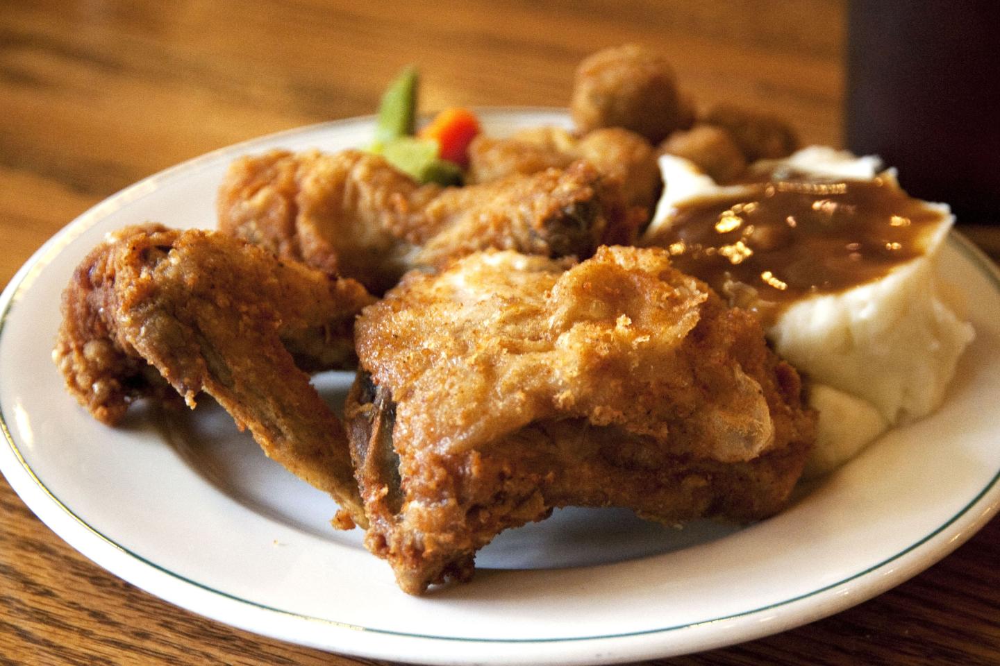 Plate of fried chicken with mashed potatoes, gravy, and corn.