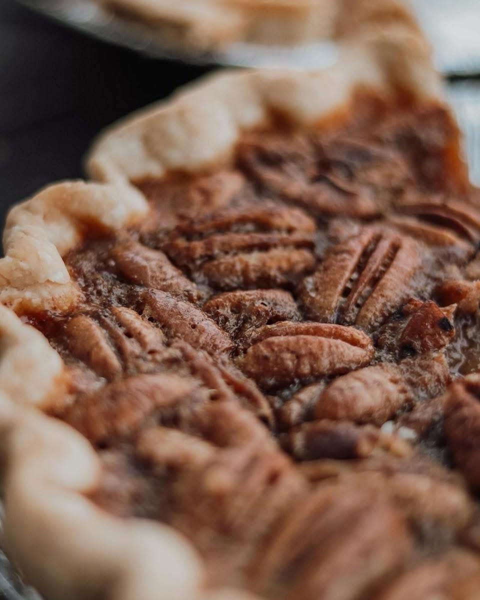 Close-up of a golden pecan pie with a flaky crust.