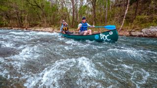 Kayakers head over the rushing white waters of the Buffalo National River