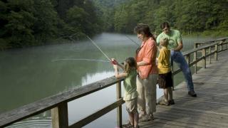 A family fishing from the pier on Mirror Lake in Arkansas