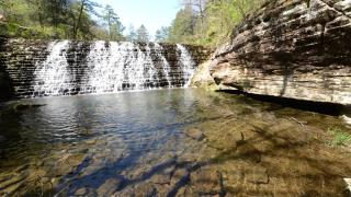 Waterfalls with trees and rocks around at Gunner Pool Recreation Area