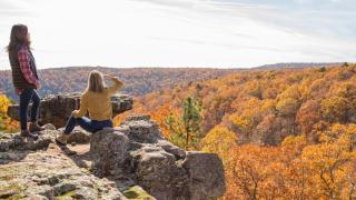 Hikers looking out on a fall foliage vista