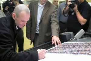 Jockey Calvin Borel signs trading cards marking his 5,000 landmark win. The cards were printed at Arkansas Graphics in Little Rock yesterday.